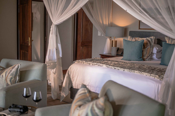 Savanna Lodge: Großes Bett unter Moskitonetz mit Fernglas