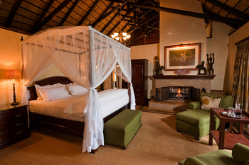 Mateya Safari Lodge: Elegantes Schlafzimmer mit Kamin und Baldachin