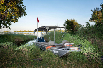 Losika Elephant Camp: Expeditionsboot am Flussufer im goldenen Licht
