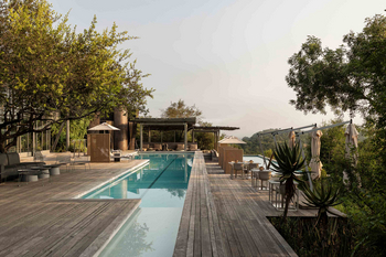 Singita Lebombo Lodge: Poolterrasse mit Liegen vor weiten Buschhügeln