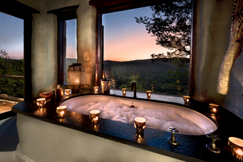 andBeyond Phinda Rock Lodge: Sprudelbad mit Champagner bei Dämmerung im Busch
