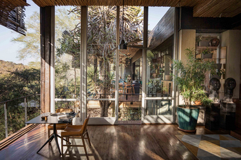 Singita Sweni Lodge: Essbereich mit Lederstühlen und Glaswand