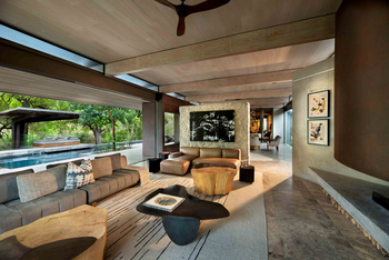 Cheetah Plains: Wohnlounge mit grauem Ecksofa und Baumfotografie
