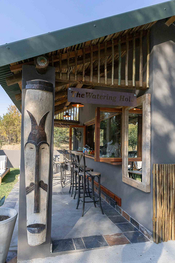 Notten's Bush Camp: Rustikale Buschbar mit Holztheke und Maskenskulptur