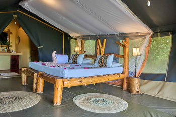Ikoma Tented Camp: Bett mit Handtüchern und Blütenblättern