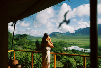 Mkomazi Wilderness Retreat: Gast trinkt auf Veranda, Vogel fliegt.