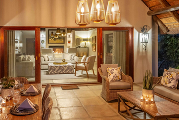 Savanna Lodge: Lounge mit Kamin und gedecktem Holztisch