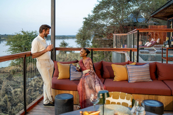 Anantara Tented Camp Kafue River: Gäste genießen Sundowner auf Lounge-Sofa