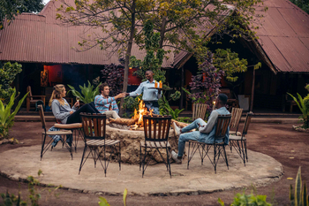 Migunga Tented Camp: Gäste genießen Sundowner am Lagerfeuer
