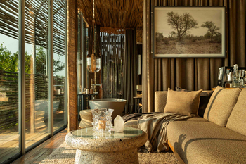 Singita Lebombo Lodge: Lounge mit Sofa und freistehender Wanne