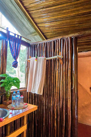 Migunga Tented Camp: Naturholzwand und Metallwaschbecken im Safari-Bad
