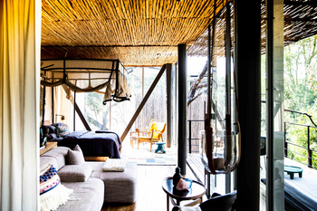 Singita Sweni Lodge: Himmelbett mit Moskitonetz und bestickten Kissen