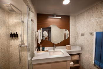 andBeyond Galapagos Explorer: Modernes Badezimmer mit Mosaik und geschwungenem Spiegel