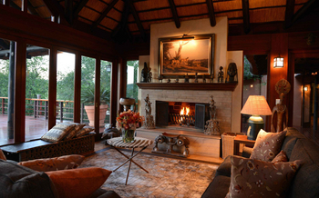 Mateya Safari Lodge: Afrikanischer Salon mit Wandleuchter und Kamin