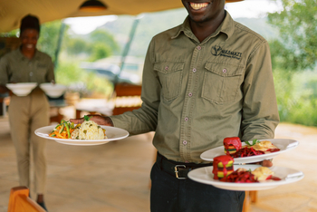 Mkomazi Wilderness Retreat: Servicemitarbeiter präsentiert Gourmetgerichte mit Lächeln