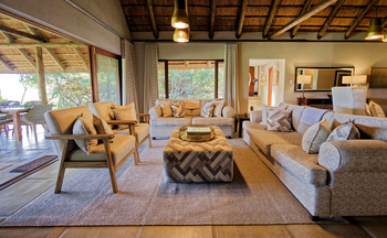 Savanna Lodge: Wohnlounge mit Ecksofa und Strohdach