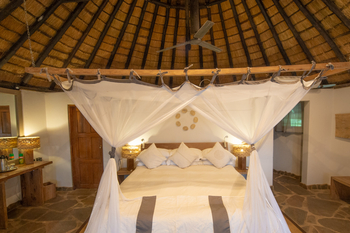 Kanyemba Lodge: Doppelbett auf Steinfußboden