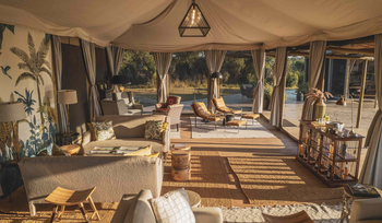 The River Camp: Safari Canvas Lounge mit Ledersesseln und botanischen Kissen
