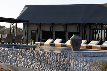 Otjiwa Thornbush Tented Camp: Pooldeck mit weißen Sonnenliegen und Steinurne