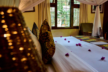 Moivaro Lodge: Safari-Schlafzimmer mit Moskitonetz und Rosenblüten