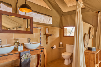 Mkomazi Wilderness Retreat: Safari-Badezimmer mit Doppelwaschtisch und Leinwandwänden