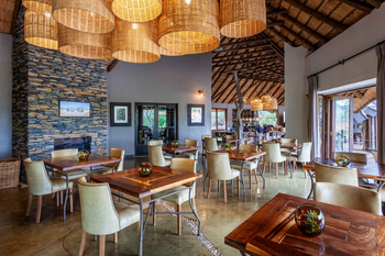 Madikwe Hills Private Game Lodge: Rustikaler Speiseraum mit Kamin und Holztischen