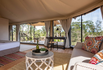 The River Camp: Suite Schlafzimmer mit geschnitztem Couchtisch