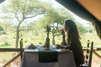 Ikoma Tented Camp: Gast genießt Getränk im offenen Speiseraum