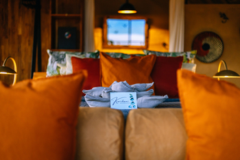 Mkomazi Wilderness Retreat: Schlafzimmer mit goldener Beleuchtung und Willkommensgruß