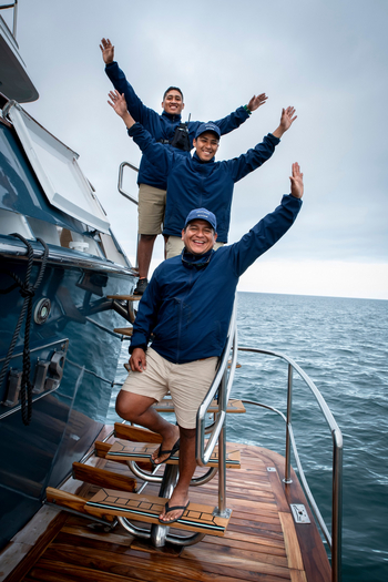 andBeyond Galapagos Explorer: Drei Begleiter winken vom Teakdeck
