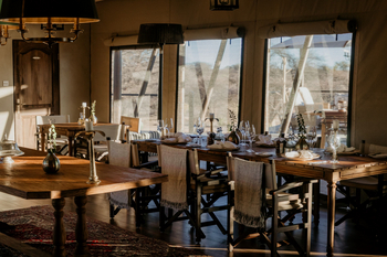 Otjiwa Thornbush Tented Camp: Speiseraum mit gedeckter Holztafel und Messinglampen