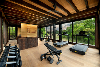 andBeyond Phinda Forest Lodge: Fitnessraum mit Technogym Geräten und Panoramafenstern