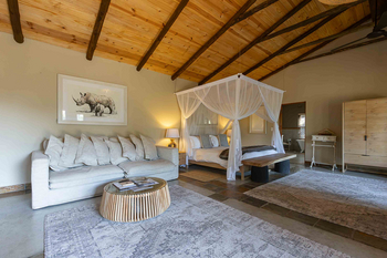Notten's Bush Camp: Schlafzimmer mit Himmelbett und grauem Sofa