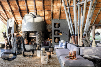Singita Boulders Lodge: Lounge with Stone Fireplace and Grey Sofa