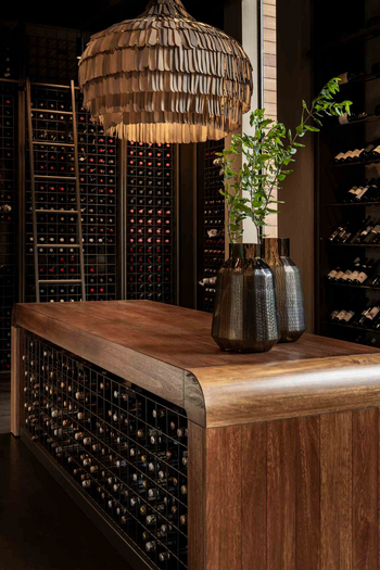 Singita Lebombo Lodge: Weinkeller mit massivem Holztisch und Lampe