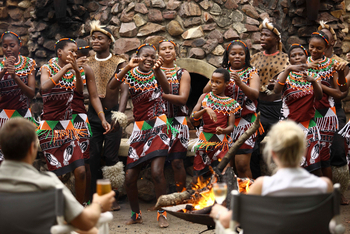 andBeyond Phinda Zuka Lodge: Traditionelle Tänzer am Lagerfeuer im Abendlicht