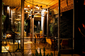 Singita Sweni Lodge: Abendliches Esszimmer mit Kamin