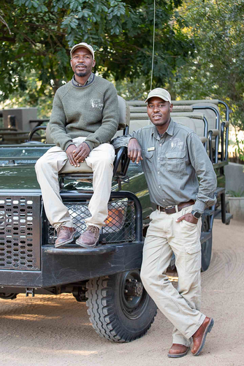 Notten's Bush Camp: Zwei Ranger entspannen am offenen Safariwagen