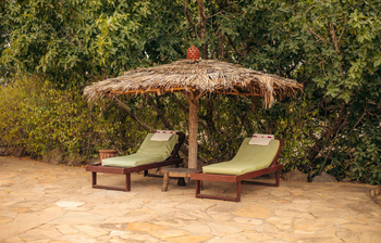 KIA Lodge: Sonnenliegen und Sonnenschirm am Pool