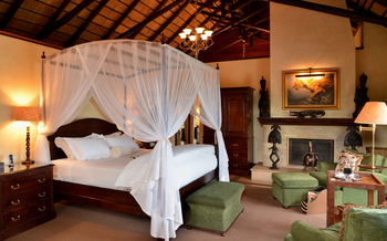Mateya Safari Lodge: Himmelbett mit Moskitonetz und Ottomane