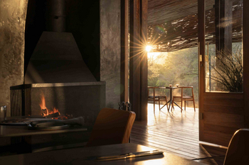 Singita Sweni Lodge: Lounge mit Kamin und gedecktem Tisch
