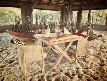 Leopard Plains: Esstisch mit Mokoro im Hintergrund