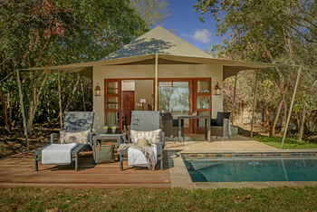 Savanna Lodge: Pooldeck mit geflochtenen Liegen und Sundowner
