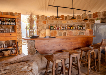 Mkomazi Wilderness Retreat: Rustikale Hartholzbar mit Natursteinelementen