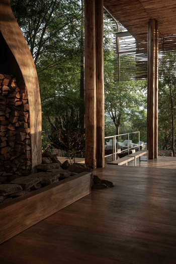 Singita Lebombo Lodge: Offene Decklounge mit Holzbank und Kaminholz