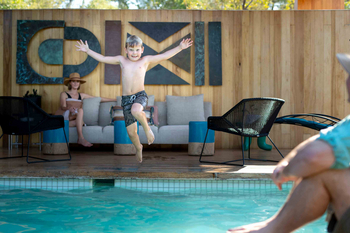 Singita Sweni Lodge: Kind springt in den sonnigen Camp-Pool