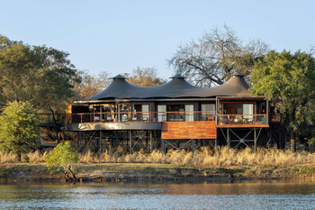 Anantara Tented Camp Kafue River: Gäste entspannen auf erhöhtem Flussdeck