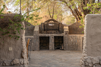Fort Sesfontein Lodge: Rustikale Steinfeuerstelle mit Grillrost und Bänken