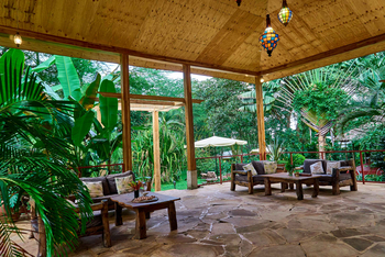 Arusha Safari Lodge: Rustikale Holzsofas im grünen mit Pflanzen