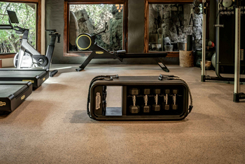 Singita Boulders Lodge: Moderner Fitnessraum mit Fenster zur Natur